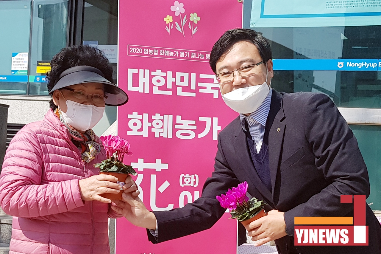 지난 18일 이성남 지부장이 시민들에게 꽃을 나눠주면 코로나19 극복과 화훼 소비 운동 참여를 당부하고 있다.
